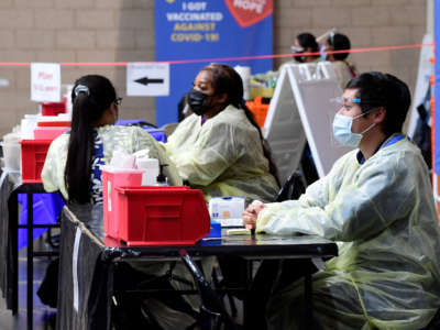 Nurses wait for COVID-19 vaccination patients to arrive at the Jessie Turner Health and Fitness in Fontana on March 22, 2022.