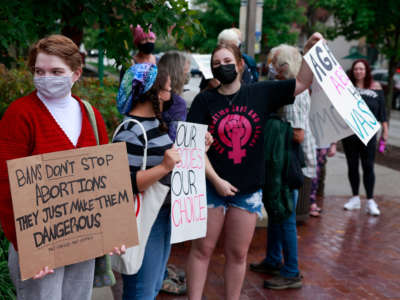 Demonstrators gather with placards in support of reproductive rights at the Sample Gates at Indiana University on October 2, 2021, in Bloomington, Indiana.