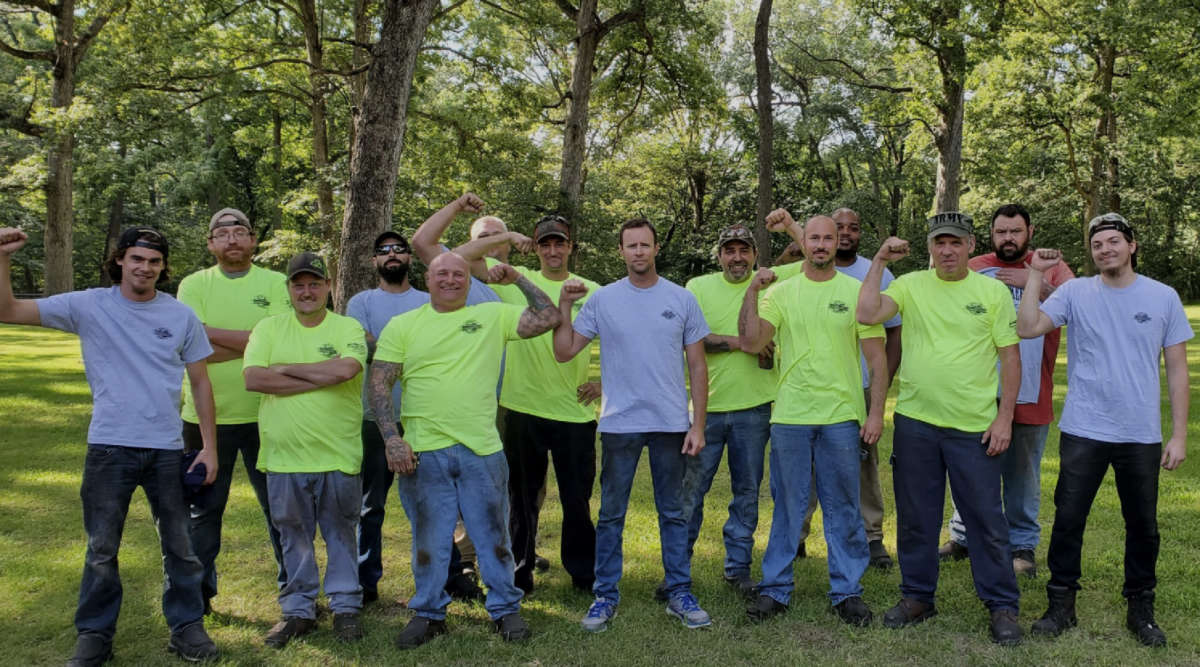 Iron workers stand together with their fists up in solidarity.