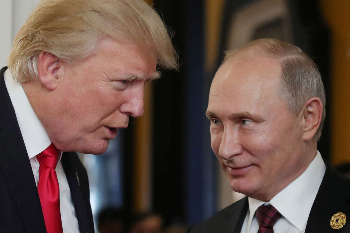 President Donald Trump chats with Russia's President Vladimir Putin as they attend the APEC Economic Leaders' Meeting in the central Vietnamese city of Danang on November 11, 2017.