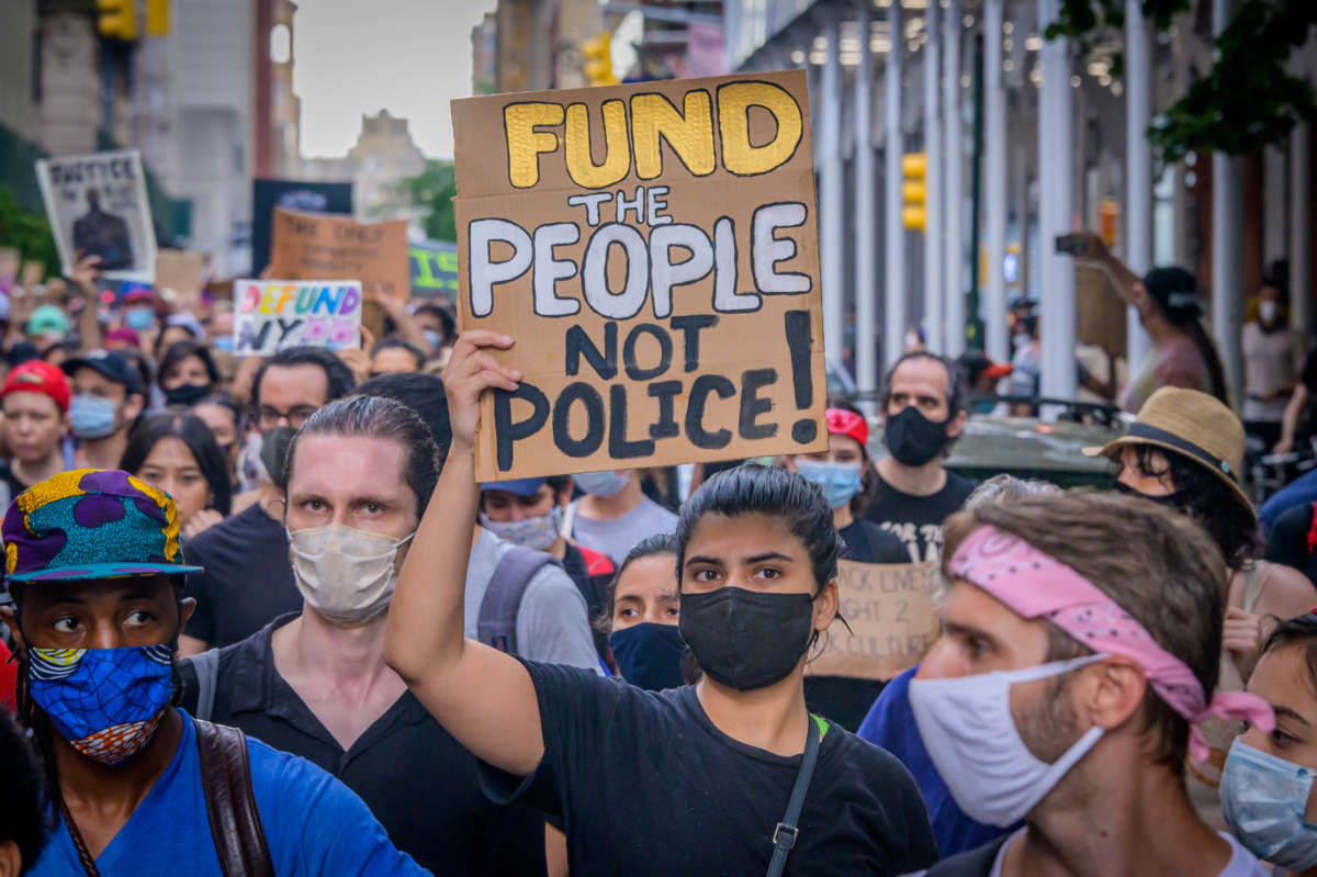 A participant holding a Defund Police sign at the protest.