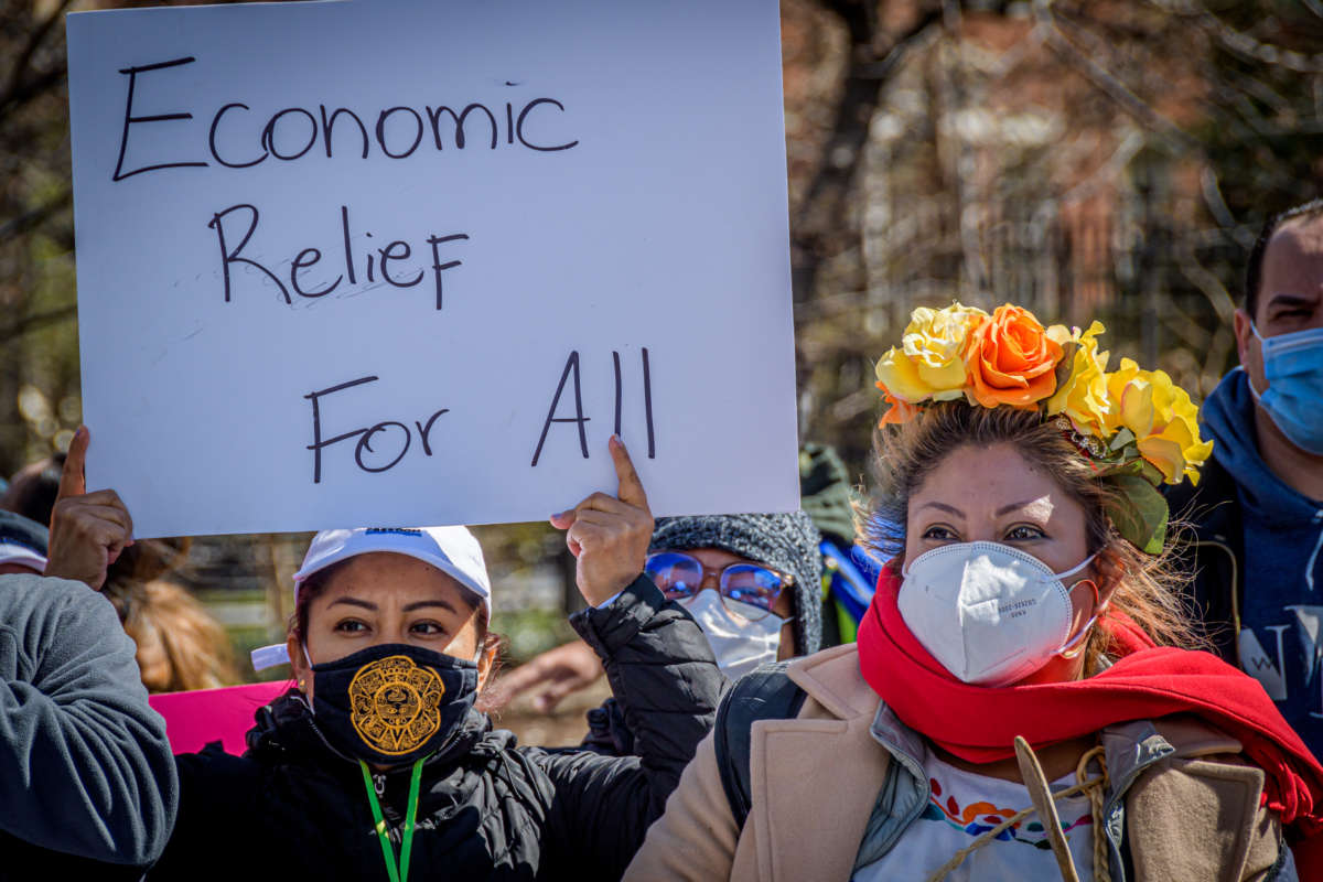 Protester holding a sign saying "Economic Relief for All"