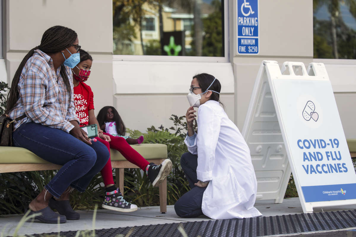 A doctor chats with a mother and her 7-year-old daughter, who got her first dose of Pfizer-BioNtech COVID-19 vaccine at Children's Hospital Arcadia Specialty Care Center on January 8, 2022, in Arcadia, California.