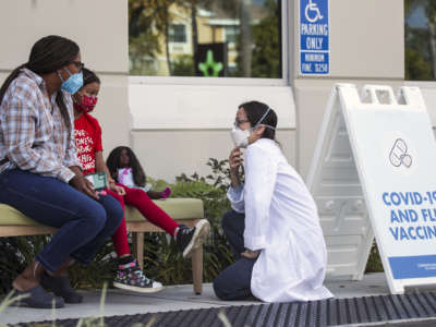 A doctor chats with a mother and her 7-year-old daughter, who got her first dose of Pfizer-BioNtech COVID-19 vaccine at Children's Hospital Arcadia Specialty Care Center on January 8, 2022, in Arcadia, California.