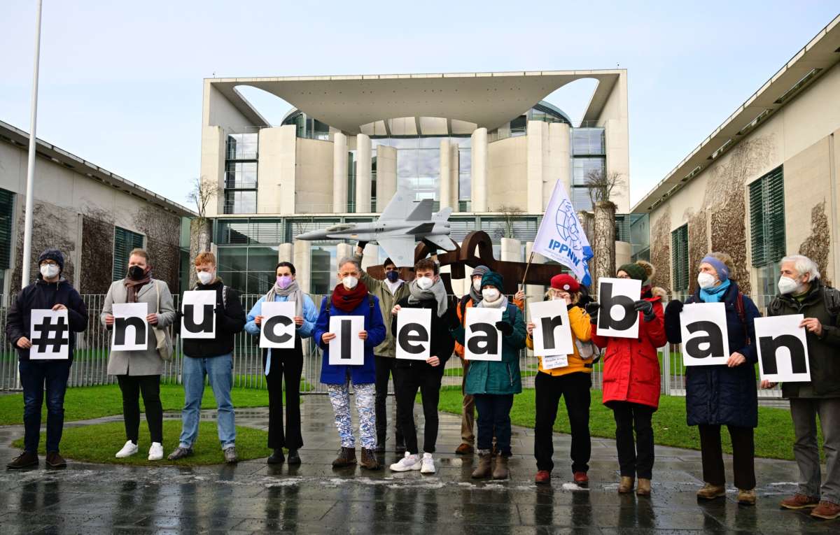 Members of International Physicians for the Prevention of Nuclear War and International Campaign to Abolish Nuclear Weapons hold signs reading "#nuclear ban" as they demonstrate in front of the German Chancellery for nuclear bans in Berlin, Germany, on January 22, 2022.