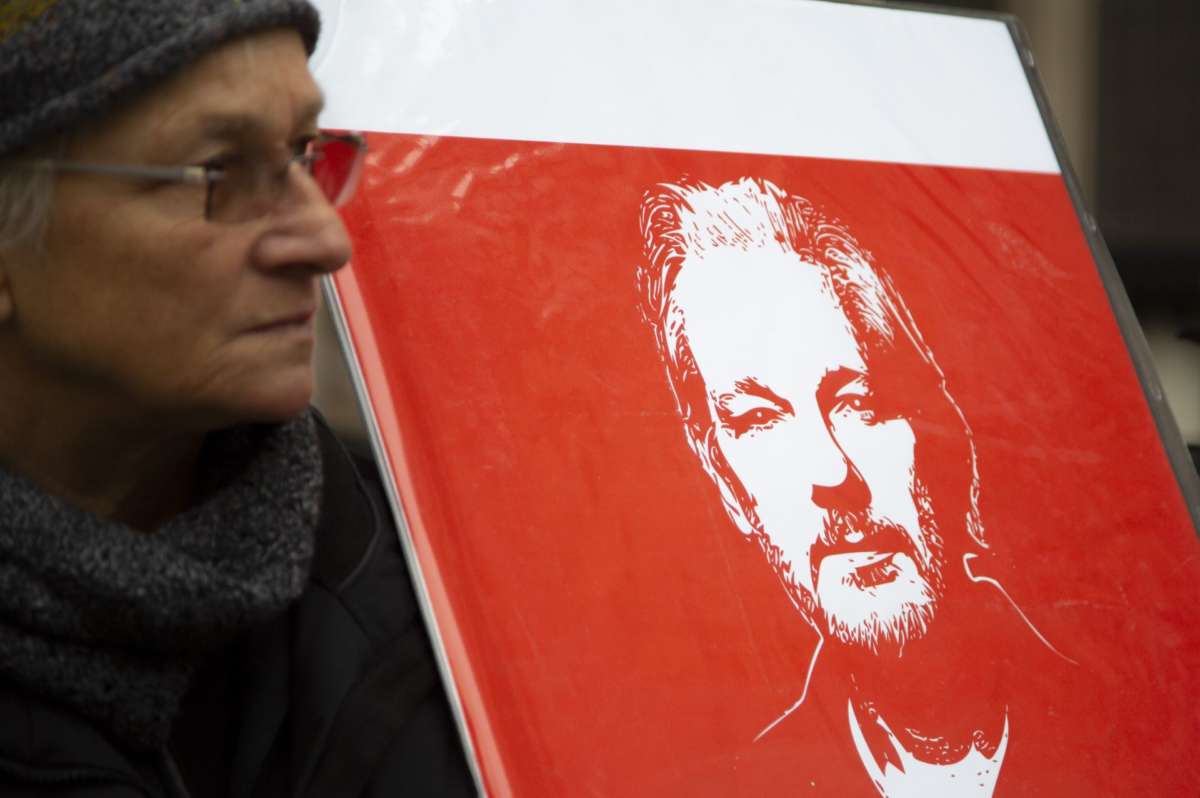 Protester for Julian Assange holds up sign