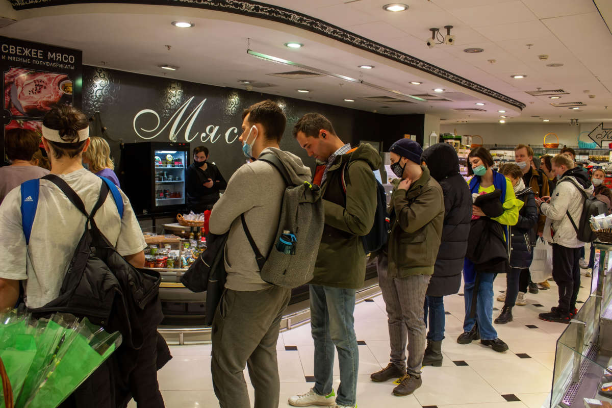 People line up to withdraw U.S. dollars at a Tinkoff ATM in a supermarket on Tverskaya street in Moscow, Russia, on March 3, 2022. The invasion of Ukraine by the Russian military has sent the Russian ruble plummeting, leading uneasy people to line up at banks and ATMs to withdraw U.S. dollars as they worry that their saving would devalue even more in the near future.