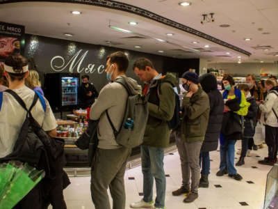 People line up to withdraw U.S. dollars at a Tinkoff ATM in a supermarket on Tverskaya street in Moscow, Russia, on March 3, 2022. The invasion of Ukraine by the Russian military has sent the Russian ruble plummeting, leading uneasy people to line up at banks and ATMs to withdraw U.S. dollars as they worry that their saving would devalue even more in the near future.