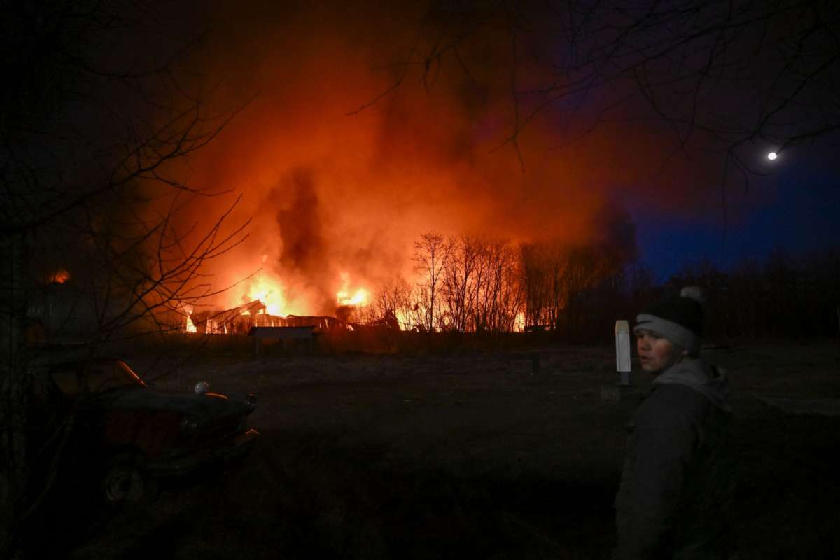 A boy in Ukraine watches burning wreckage