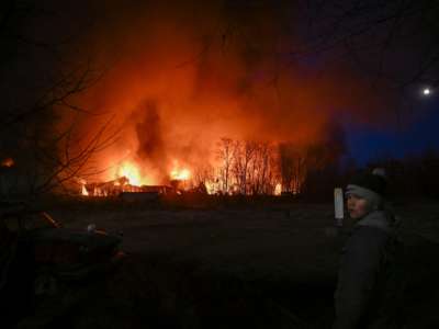 A boy in Ukraine watches burning wreckage