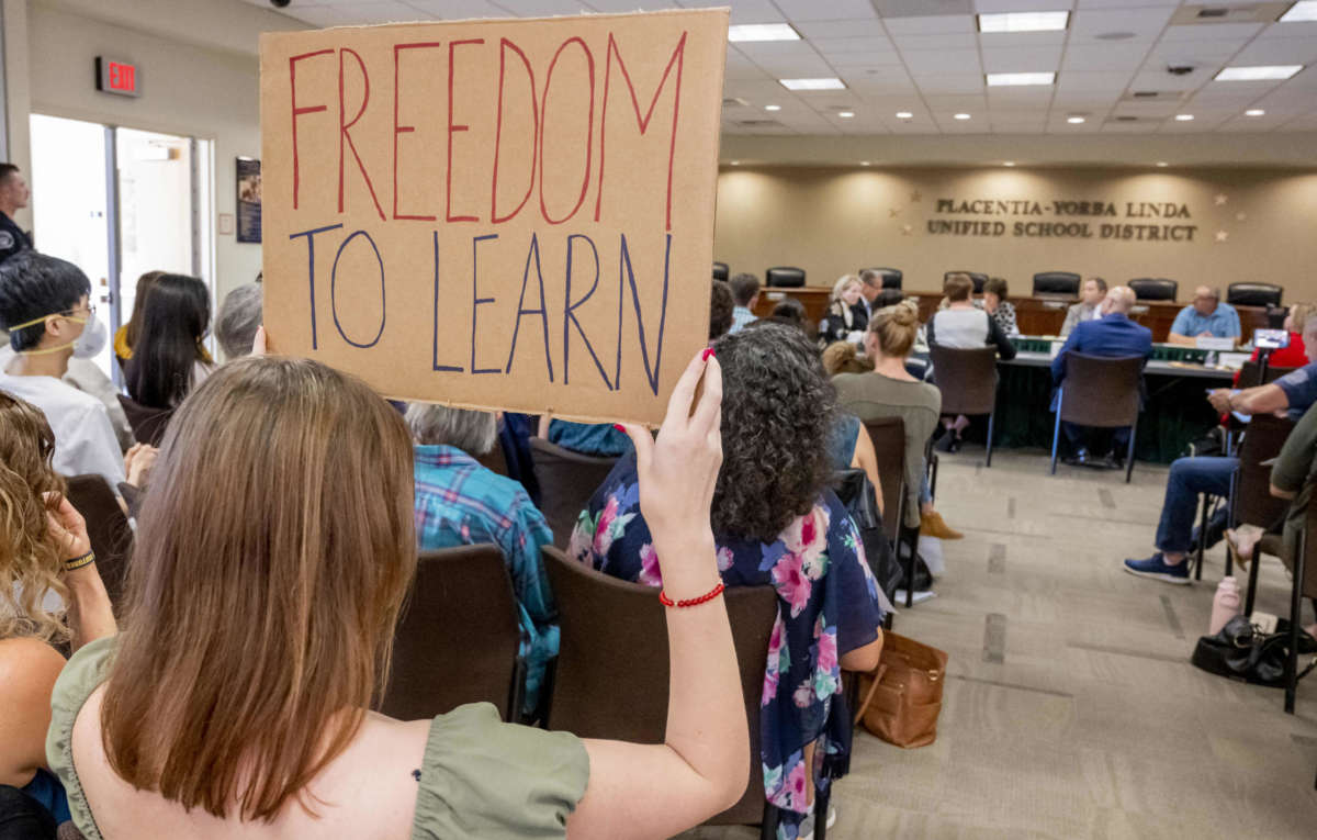 A student holds up a sign against banning CRT as members of the Placentia-Yorba Linda Unified School Board meet in Placentia, California, on Wednesday, March 23, 2022, to consider banning it in the district.