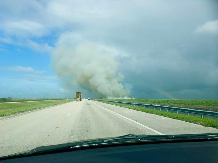 Burning sugar cane and a rainbow near Clewiston, on the route to Glades County, Florida.