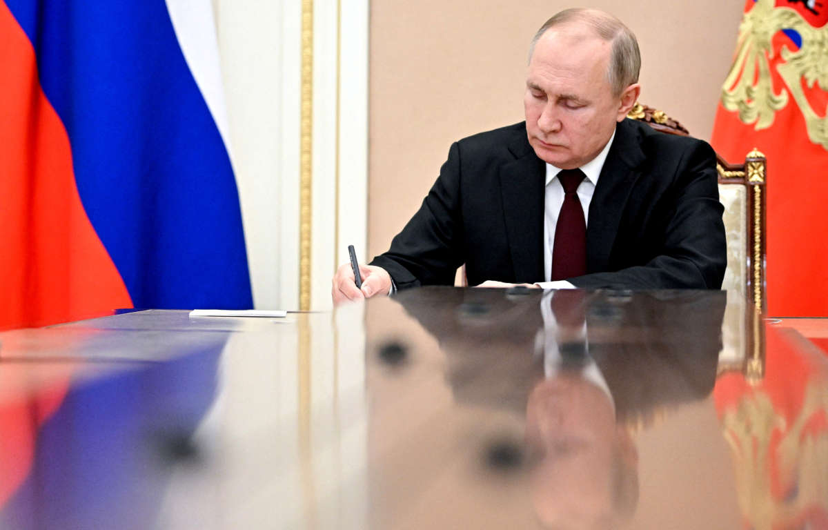 Russia's President Vladimir Putin writes as he chairs a meeting on economic issues in Moscow on February 17, 2022.