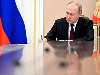Russia's President Vladimir Putin writes as he chairs a meeting on economic issues in Moscow on February 17, 2022.