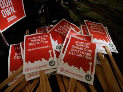 Picket signs are pictured at a rally in support of workers of two Seattle Starbucks locations that announced plans to unionize, during an evening rally at Cal Anderson Park in Seattle, Washington, on January 25, 2022.