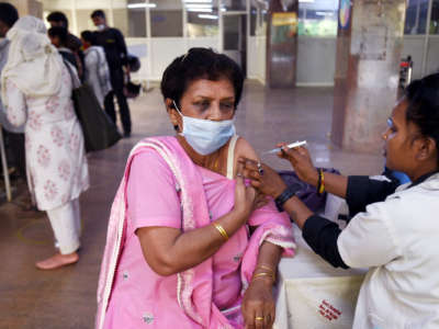 An elderly woman recieves a dose of the covid-19 vaccine