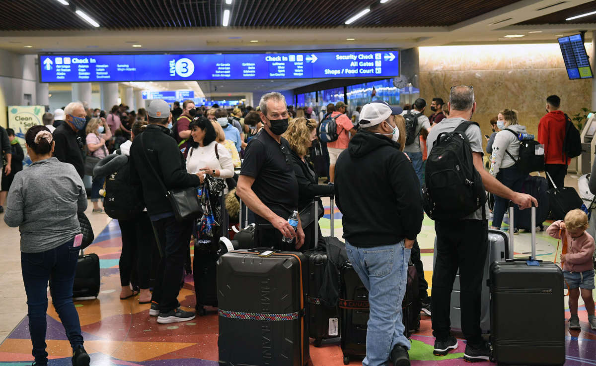 Spring break passengers wait in a TSA security line at Orlando International Airport on March 19, 2022.