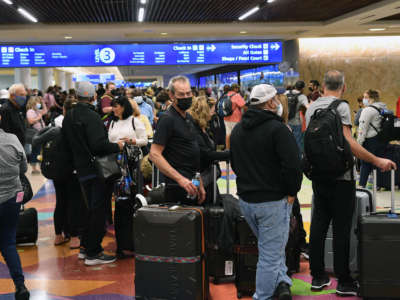 Spring break passengers wait in a TSA security line at Orlando International Airport on March 19, 2022.