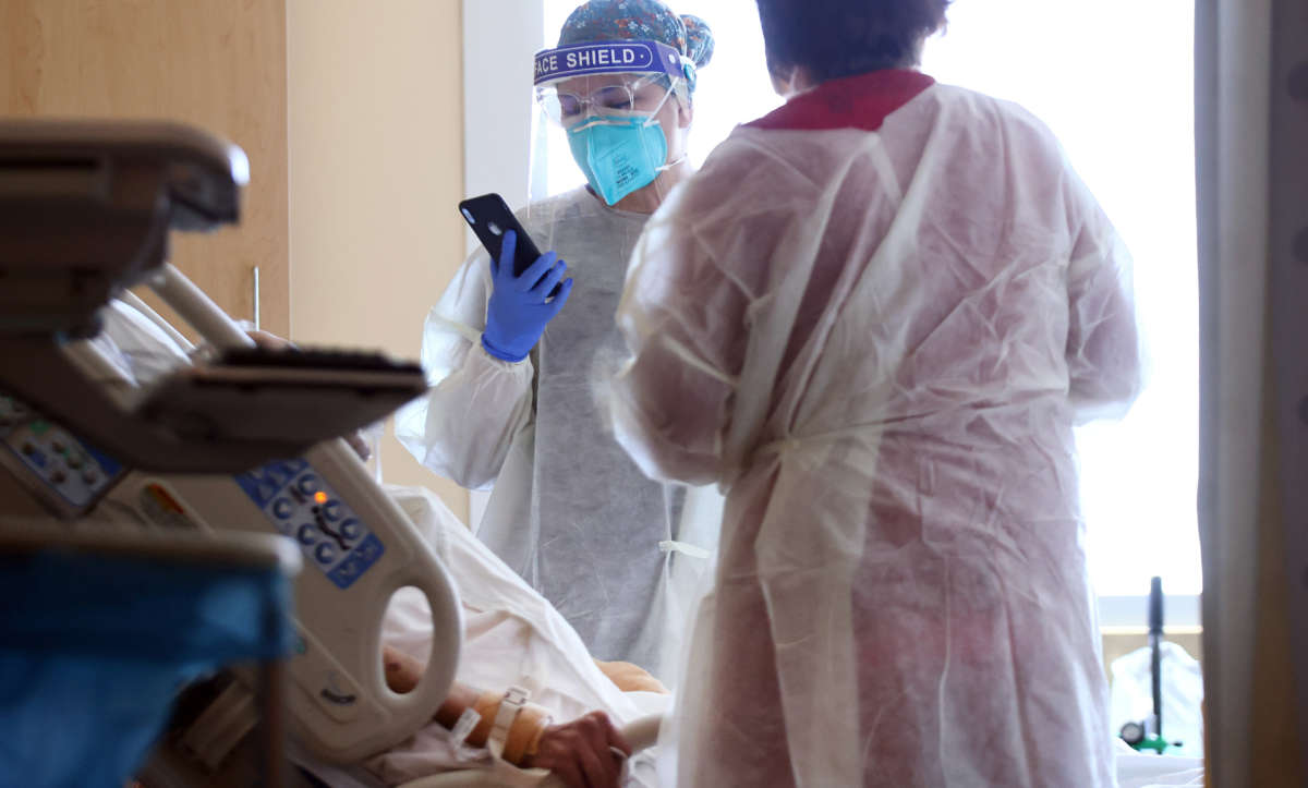 A nurse holds a phone during a video call with the family member of a patient in the improvised COVID-19 unit at Providence Holy Cross Medical Center in the Mission Hills neighborhood on July 30, 2021, in Los Angeles, California.