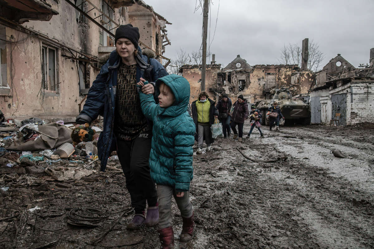 Civilians walk through a destroyed neighborhood in Eastern Mariupol that has recently come under control of Russian / pro-Russian forces on April 14, 2022.