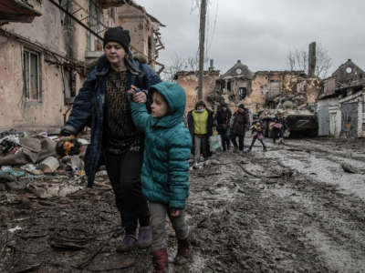 Civilians walk through a destroyed neighborhood in Eastern Mariupol that has recently come under control of Russian / pro-Russian forces on April 14, 2022.