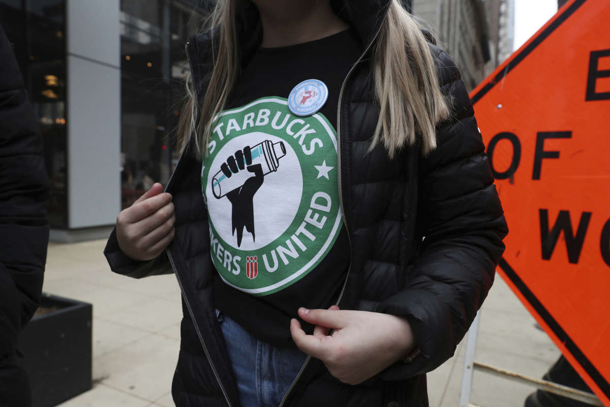 A Starbucks worker wears a t-shirt and button promoting unionization, outside a Chicago location on April 7, 2022.