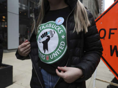 A Starbucks worker wears a t-shirt and button promoting unionization, outside a Chicago location on April 7, 2022.