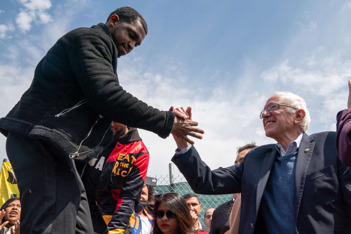 A member of the Amazon Labor Union shakes hands with Sen. Bernie Sanders at an Amazon Labor Union rally on April 24, 2022, in New York City.