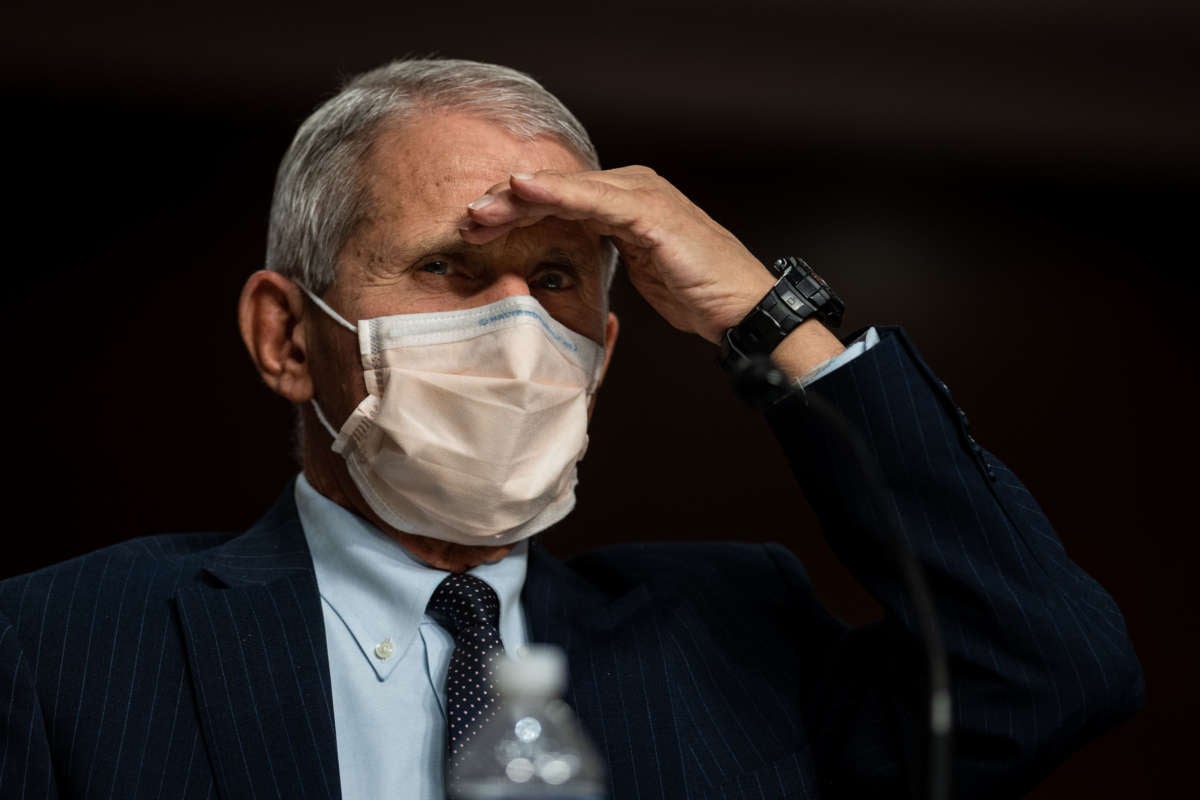 Dr. Anthony Fauci shields his eyes from light