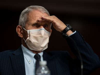 Dr. Anthony Fauci shields his eyes from light