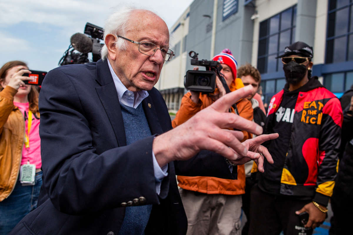 Bernie Sanders speaks while surrounded by union organizers and worker at an outdoor rally