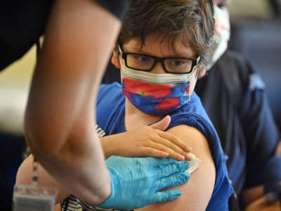 A boy receives a COVID-19 vaccine at a L.A. Care Health Plan vaccination clinic at Los Angeles Mission College in Los Angeles, California, on January 19, 2022.