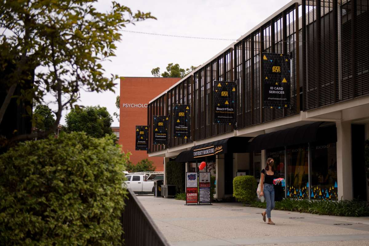 A person wears a face mask as they walk past the University Bookstore at the California State University Long Beach (CSULB) campus on August 11, 2021, in Long Beach, California.