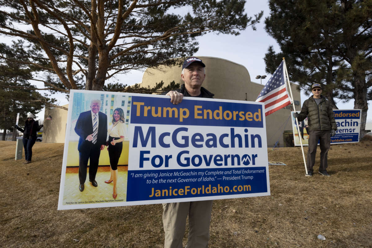 A supporter of Idaho's Lieutenant Governor Janice McGeachin's campaign for governor holds a sign picturing the candidate alongside Donald Trump on March 19, 2022, in Idaho Falls, Idaho.