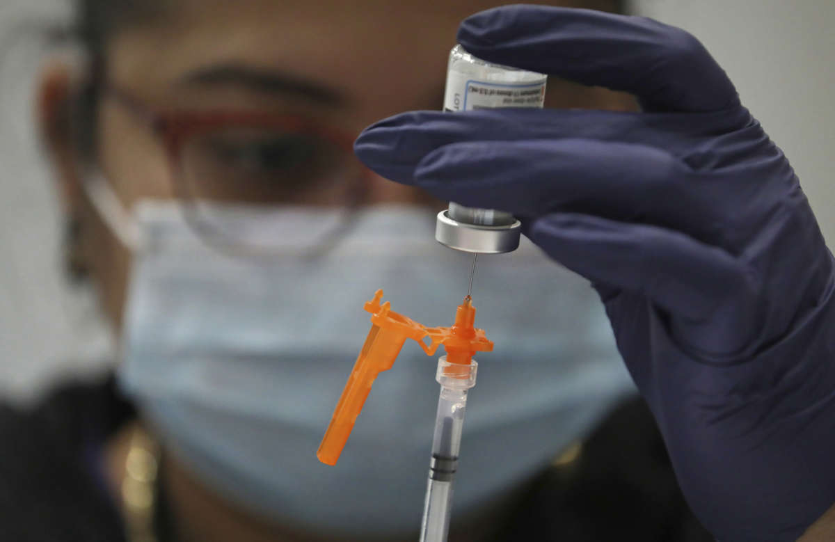 Martha Arevalo of Broadway Medical Center fills syringes with COVID-19 vaccines during a vaccination event at Chicago Teachers Union headquarters, on January 27, 2022, in Chicago, Illinois.