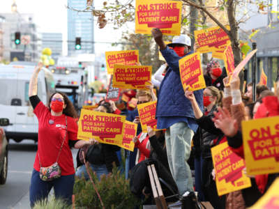 Sutter Health nurses and health care workers hold signs as they participate in a one day strike outside of the California Pacific Medical Center Van Ness Campus on April 18, 2022, in San Francisco, California.