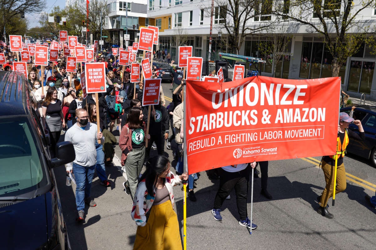 People march in the middle of Broadway during the Fight Starbucks' Union Busting rally and march in Seattle, Washington, on April 23, 2022.