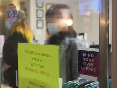 A sign reading "Mind Your Own Uterus" is taped on the check-in window at the Hope Medical Group for Women in Shreveport, Louisiana, April 19, 2022.