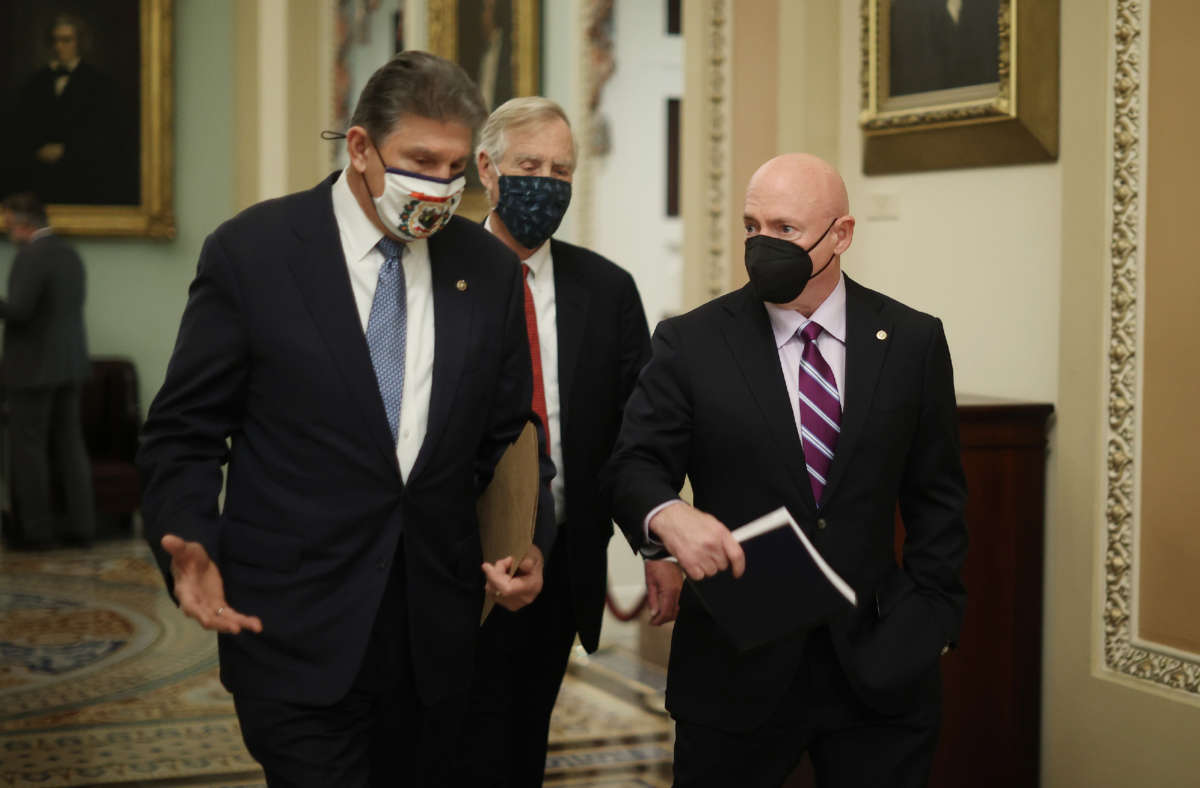 From left, Senators Joe Manchin, Sen. Angus King and Sen. Mark Kelly head to the Senate Chamber at the U.S. Capitol on February 13, 2021, in Washington, D.C.