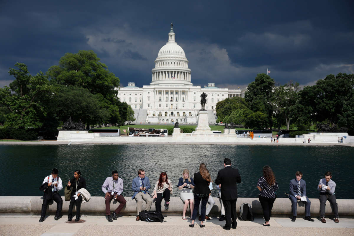 Congressional staffers eat by the reflecting pool during the 36th annual Capitol Hill ice cream party on June 6, 2018, outside the U.S. Capitol in Washington, D.C.