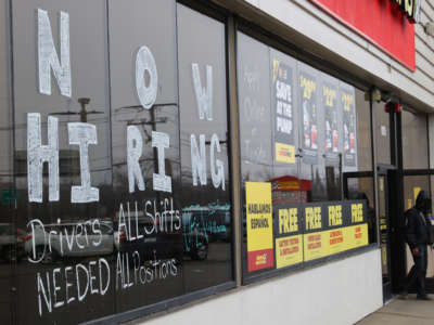 A large Now Hiring advertisement is pictured on the windows of the Advance Auto Parts store in Bay Shore, New York, on March 24, 2022.