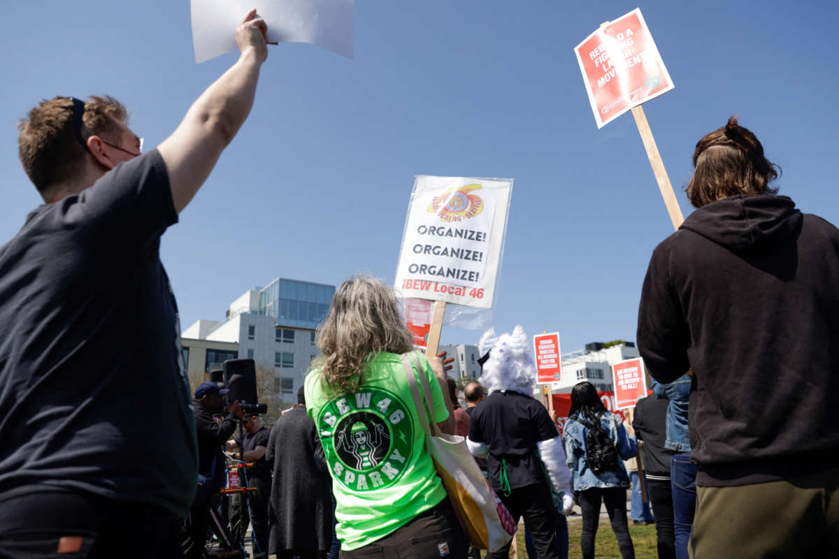 People hold signs during the "Fight Starbucks' Union Busting" rally and march in Seattle, Washington, on April 23, 2022.