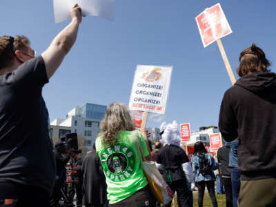 People hold signs during the "Fight Starbucks' Union Busting" rally and march in Seattle, Washington, on April 23, 2022.