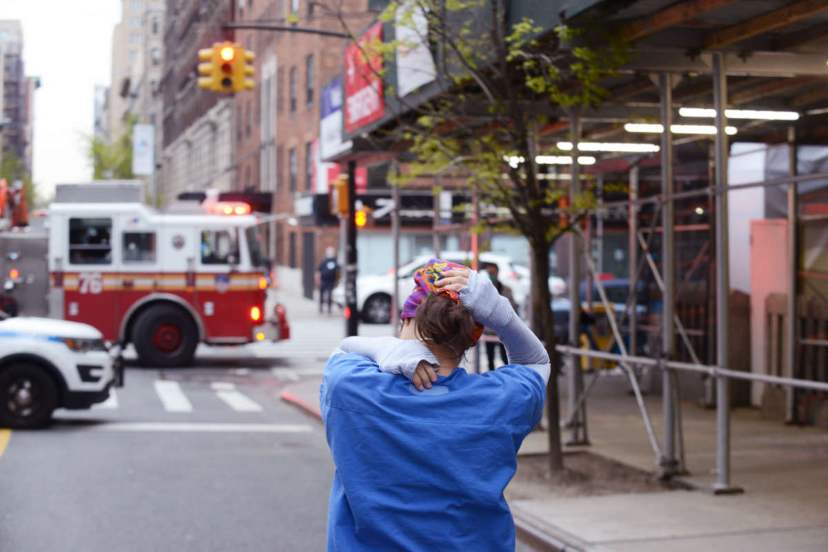 A nurse walks home with their arms over their head