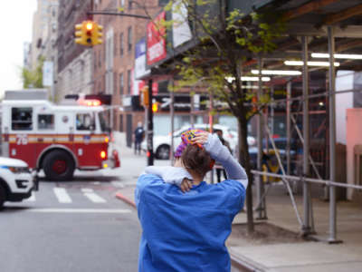 A nurse walks home with their arms over their head