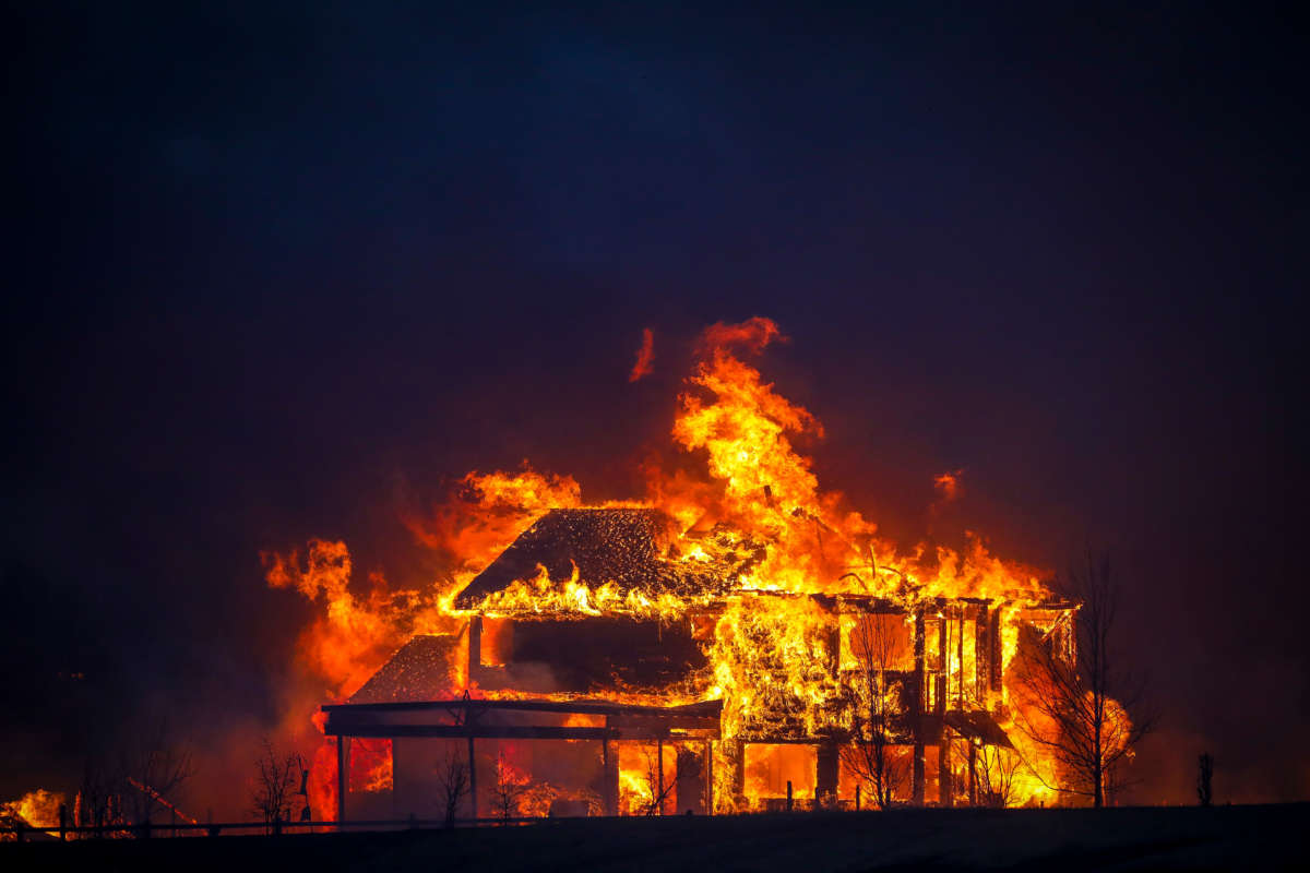 A home burns after a fast moving wildfire swept through the area in the Centennial Heights neighborhood of Louisville, Colorado, on December 30, 2021.