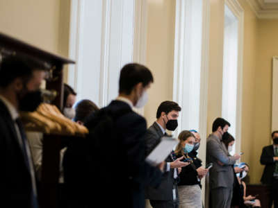 Capitol Hill staffers wait outside of a Senate weekly Democratic Party policy luncheon on February 15, 2022, in Washington, D.C.