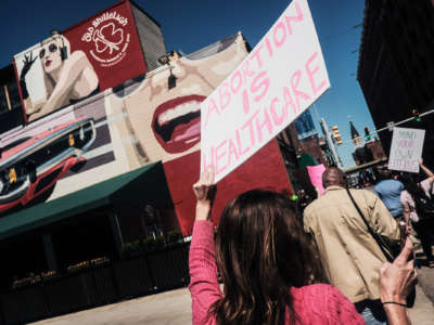A protester holds up a sign reading "ABORTION IS HEALTHCARE" during a street demonstration