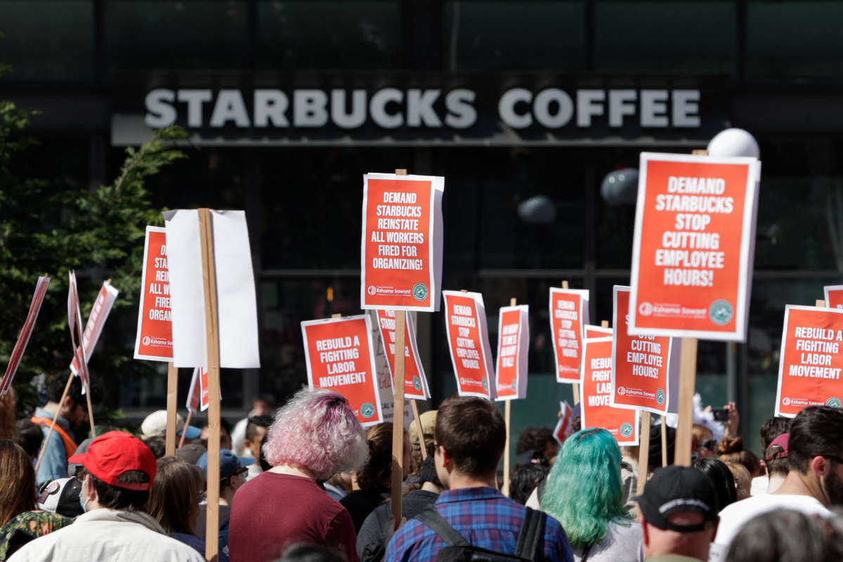 A Starbucks Coffee shop is seen in the background as people gather at Westlake Park during the "Fight Starbucks' Union Busting" rally and march in Seattle, Washington, on April 23, 2022.