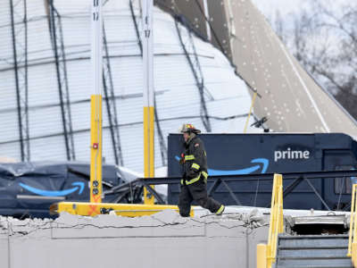 A first responder walks among the wreckage of a damaged Amazon Distribution Center on December 11, 2021, in Edwardsville, Illinois.